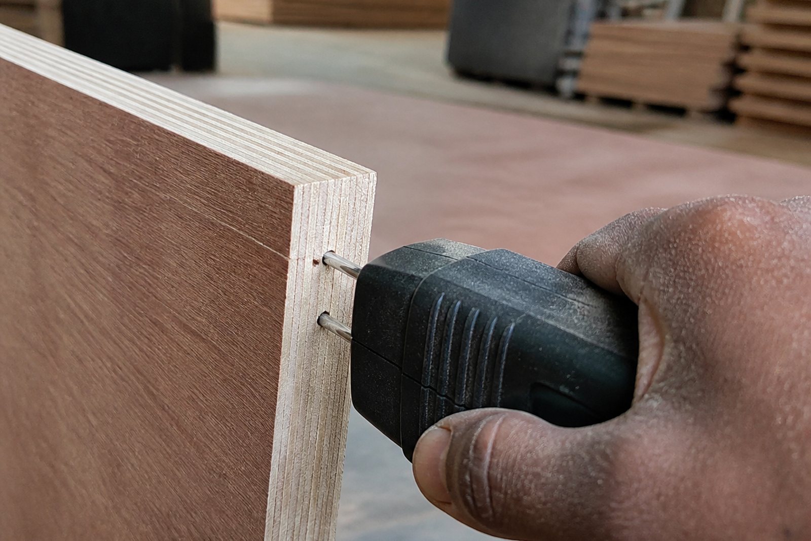 Pin-type moisture meter pressed into the edge of a finished plywood panel